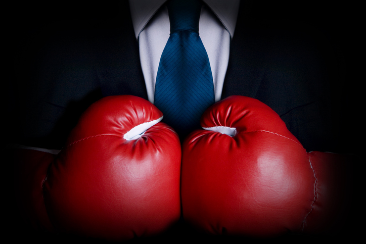 Image of a man's chest in a suit wearing boxing gloves 